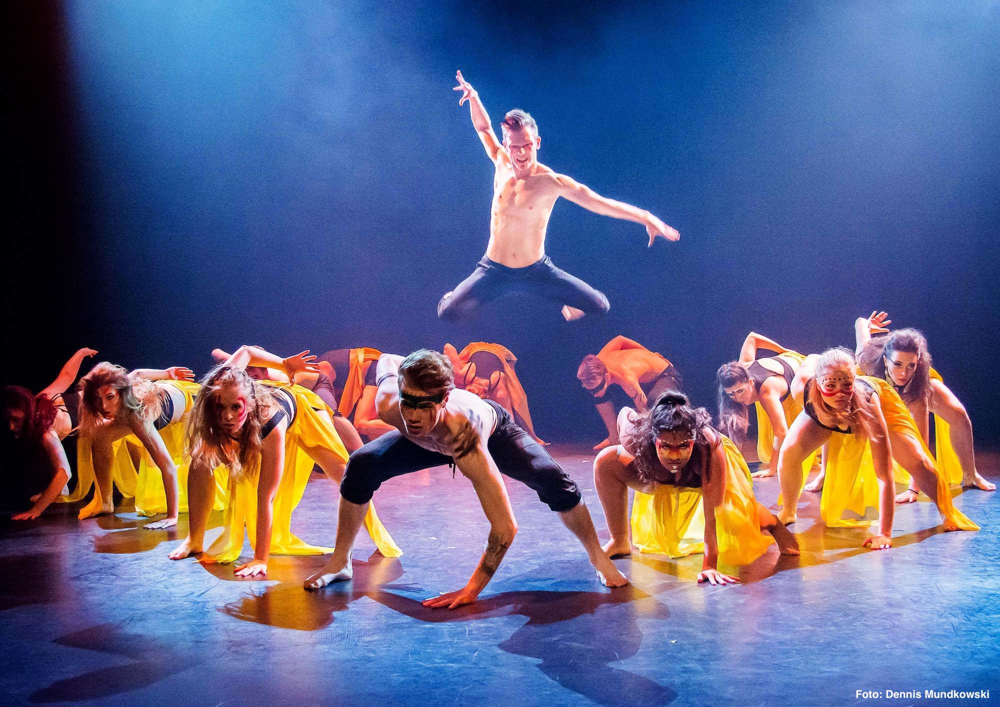 Ein Bühnenfoto einer Choreografie mit einem springenden Tänzer